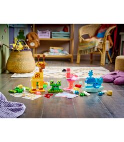 LEGO DUPLO -eläinhahmot, mukaan lukien kirahvi, sammakko, flamingo ja valas, on aseteltu puulattialle.