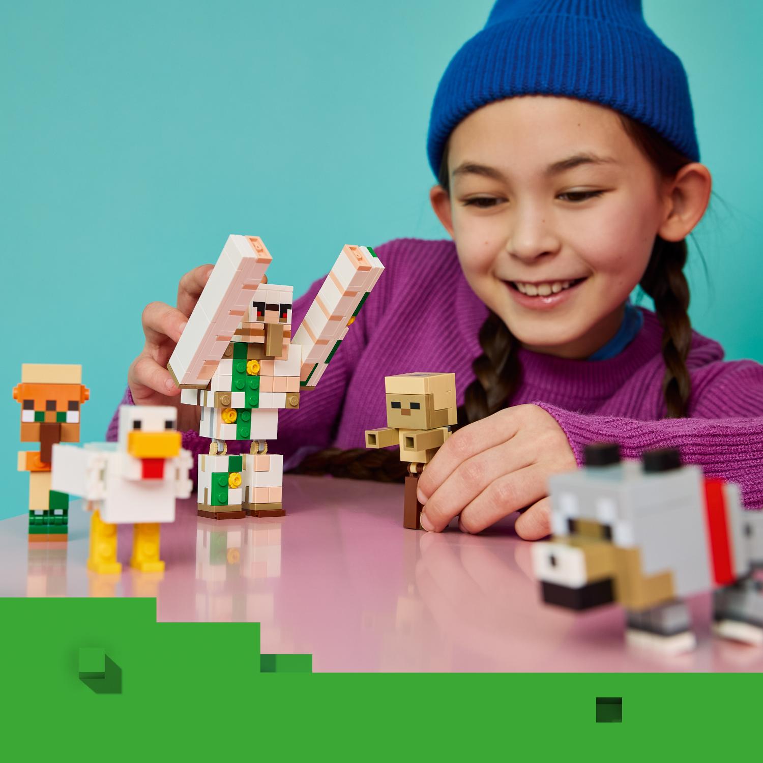 Nuori tyttö hymyilee leikkiessään pöydällä useiden Minecraft-aiheisten LEGO-hahmojen kanssa.