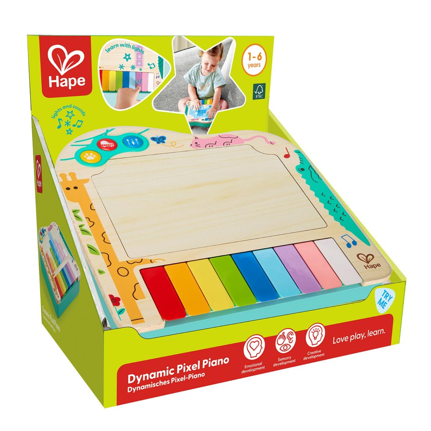 Hape Dynamic Pixel Piano -lelu esittelypakkauksessaan; siinä on värikäs näppäimistö ja puinen keskipaneeli.