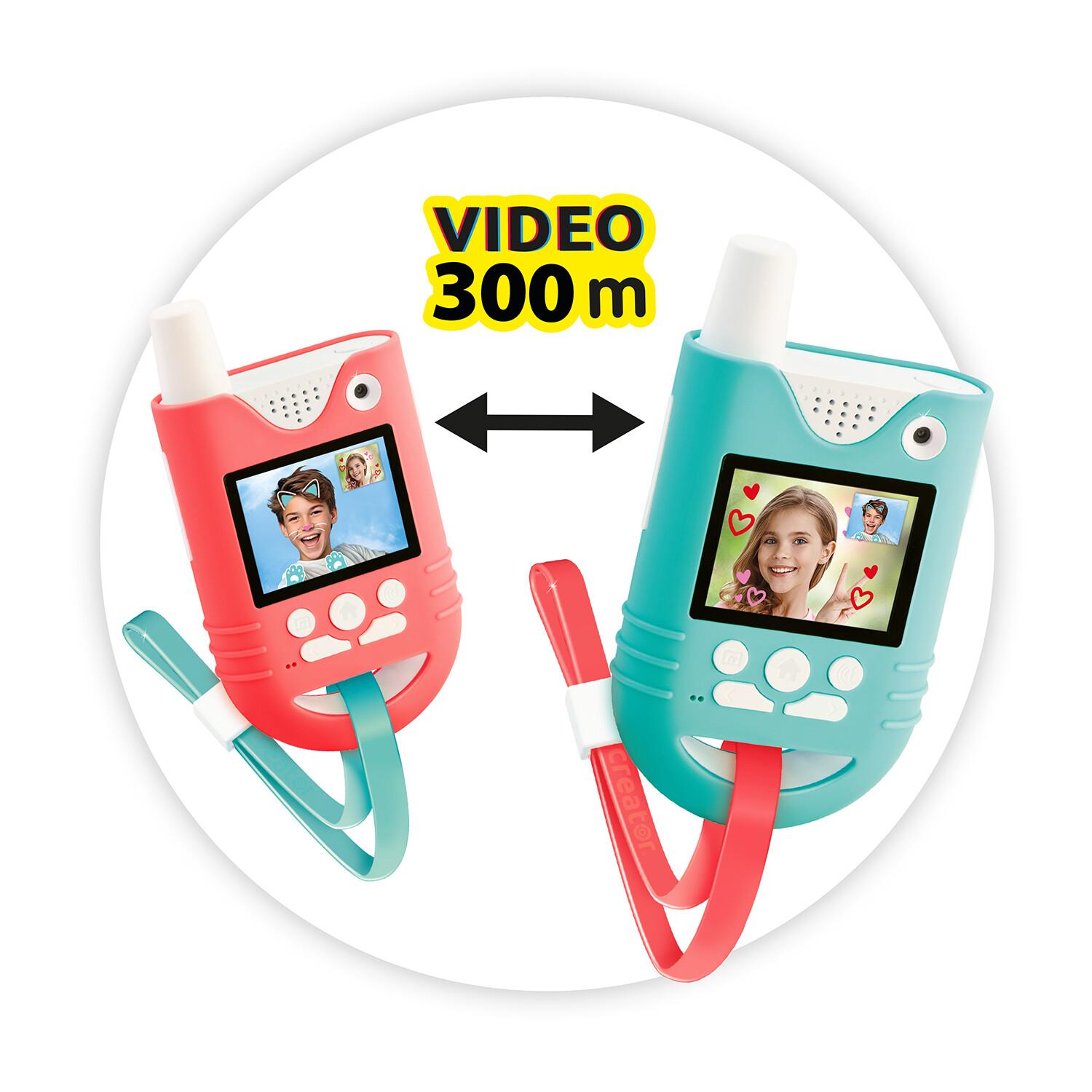 Kaksi värikästä leluradiopuhelinta, joiden videonäytöillä näkyy lasten kasvoja; ne on yhdistetty nuolilla ja tekstillä ”VIDEO 300 m above”, mikä viittaa 300 metrin videoviestintäetäisyyteen.
