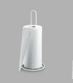 Yksinkertainen metalliteline, jossa on rulla valkoisia paperipyyhkeitä, seisoo pystyssä yksinkertaista harmaata taustaa vasten.