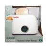 Leluleivänpaahdin laatikossa, jonka etiketissä lukee ”JUNIOR HOME Toaster With Timer” ja joka on tarkoitettu 3-vuotiaille ja sitä vanhemmille. Pakkauksessa on kuvattu valkoinen leivänpaahdin, jossa on leipäviipaleita ja ajastimen säätönuppi; pakkaus sisältää 3 kappaletta.