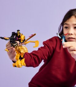 Lapsi pitää toisessa kädessään keltaista Lego-robottifiguuria ja toisessa kädessään pientä Lego-minihahmoa.
