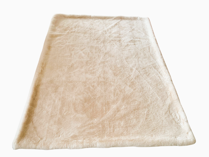 Valkoisella taustalla näkyy suorakulmainen, beige, pörröinen matto.