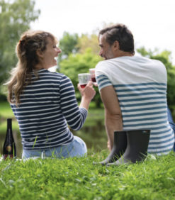 Kumisaapas tummanruskea nurmikolla, taustalla ihmisiä